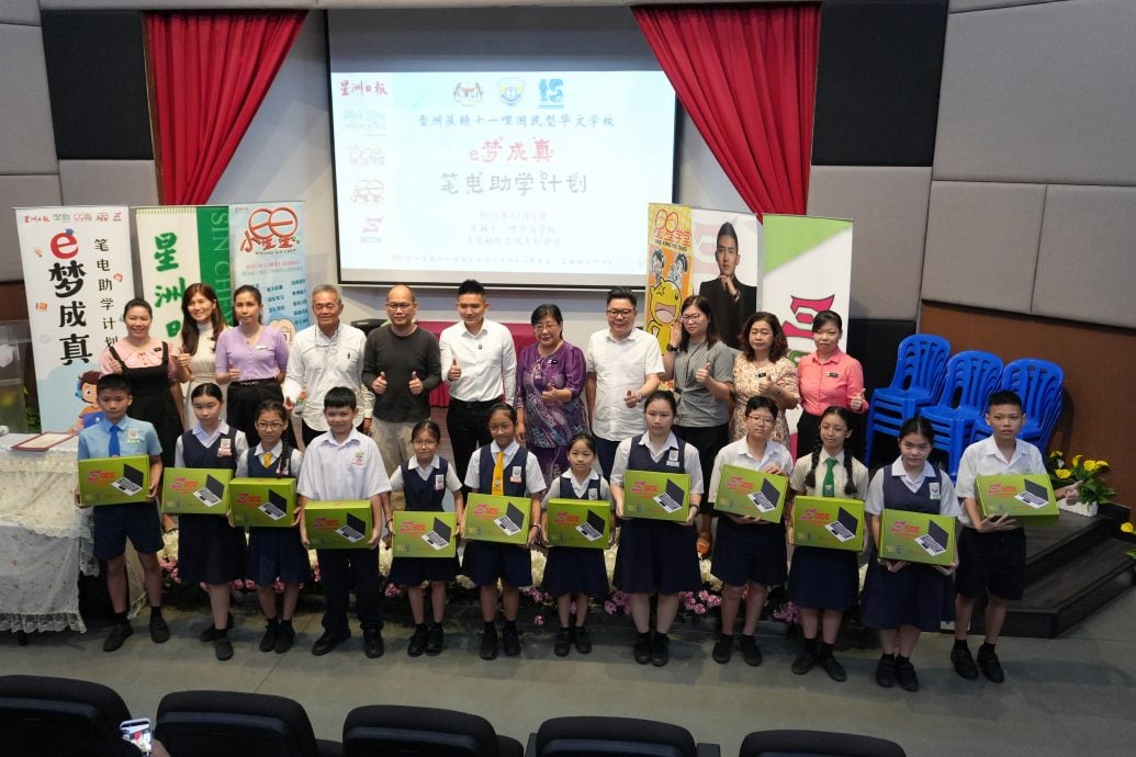 Students receiving certified refurbished laptops at an E-Dream Come True hand-over ceremony with Sin Chew Daily
