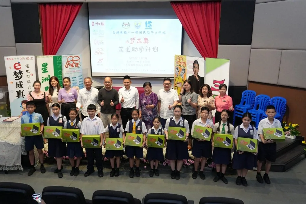 Students receiving certified refurbished laptops at an E-Dream Come True hand-over ceremony with Sin Chew Daily