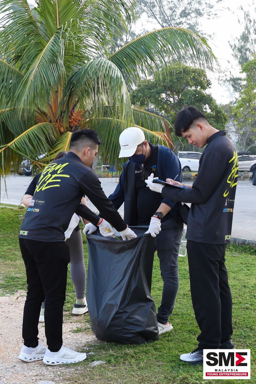 Team SCE members in branded jerseys collecting litter into bags at a community clean-up
