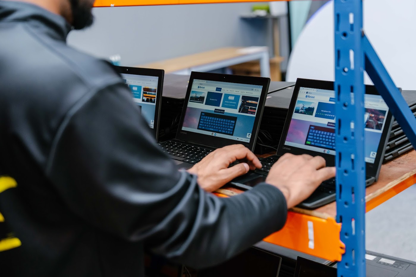 An SCE technician running quality-control retests on refurbished laptops